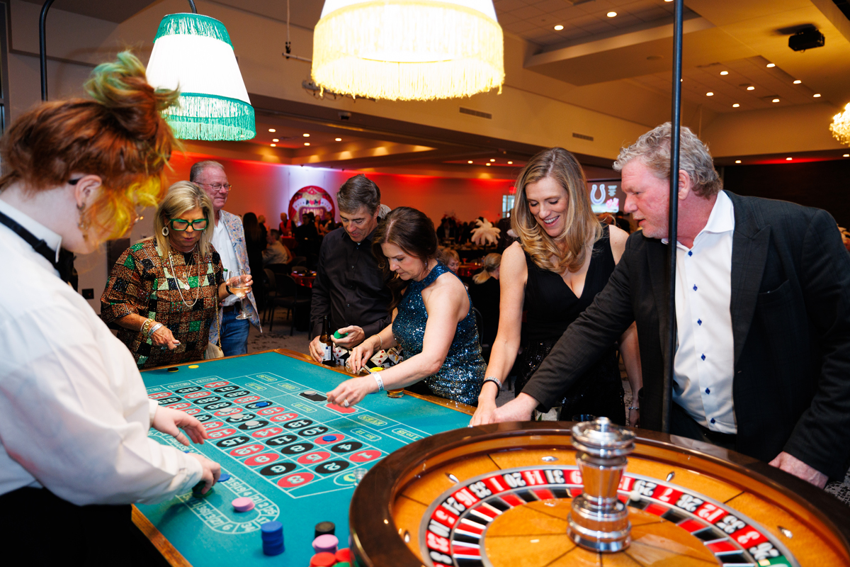 Menschen und Croupier an einem Roulette-Tisch